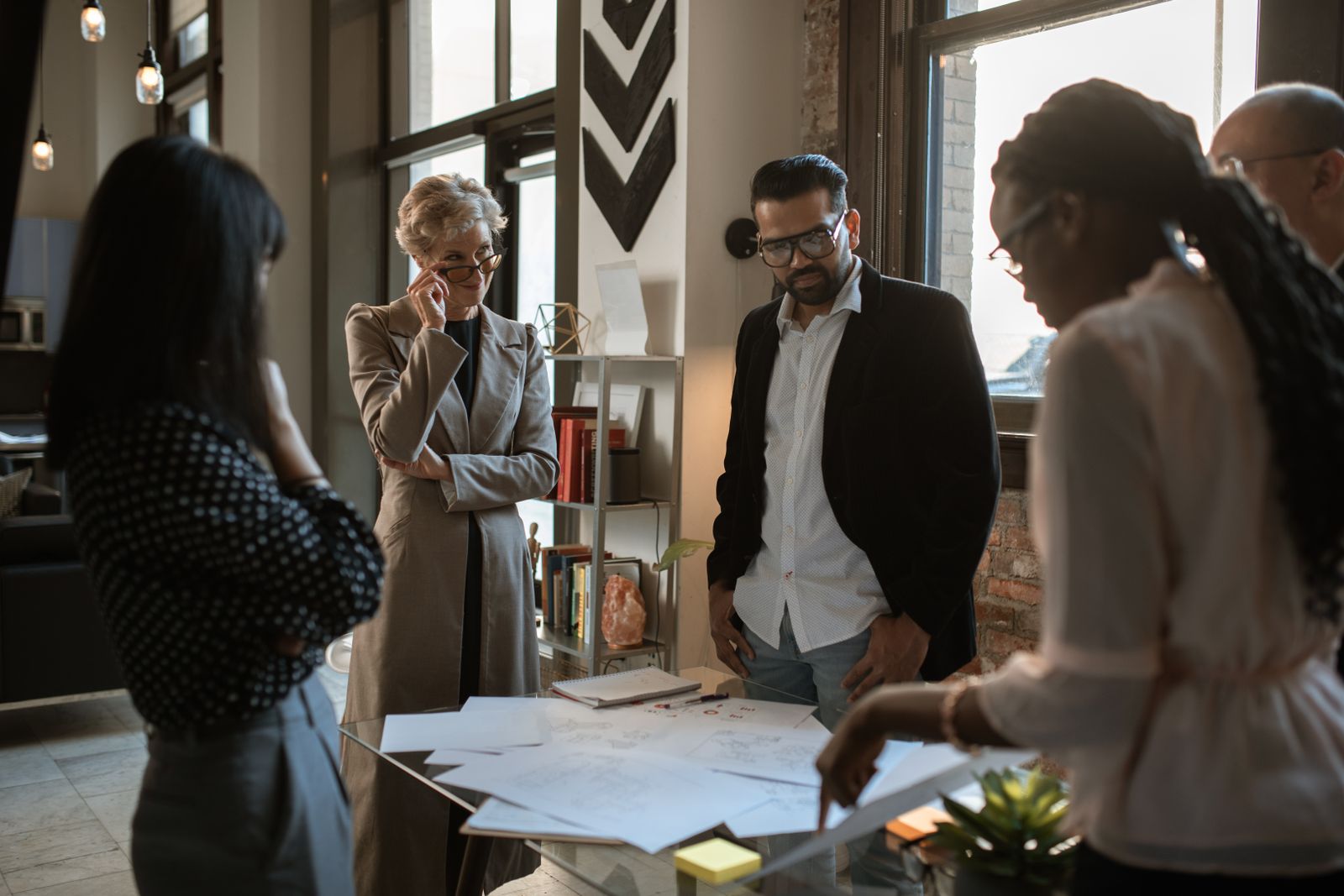 A diverse group of professionals discussing project plans in a modern office setting.